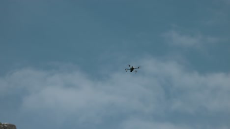 dron dji air latający na niebie na tle niebieskiego nieba z lekkimi białymi chmurami