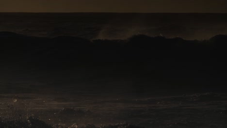 large dark waves roll into the coast of hawaii and crash into the shore in slow motion during a big storm 1