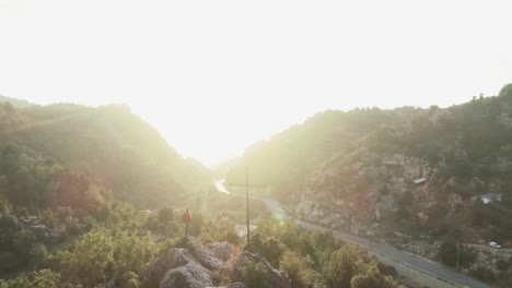 Astonishing-aerial-view-of-amazing-mountain-peak-landscape-at-sunset,-man-on-top-admires-panorama,-Lebanon,-circle-pan