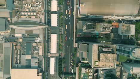 Cinematic-urban-drone-footage-of-an-aerial-smoky-view-flying-over-skyscrapers-and-boulevards-in-the-middle-of-downtown-Bangkok,-Thailand-during-burning-season-looking-down-from-a-bird's-point-of-view