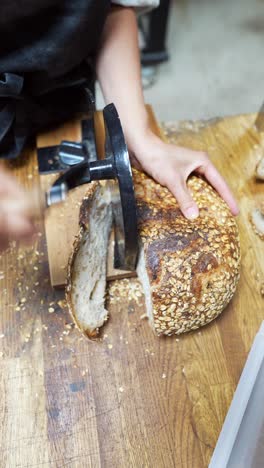 baker slicing a loaf of bread