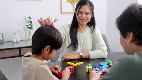 A family joyfully engages in building with colorful blocks at a table, fostering creativity and connection