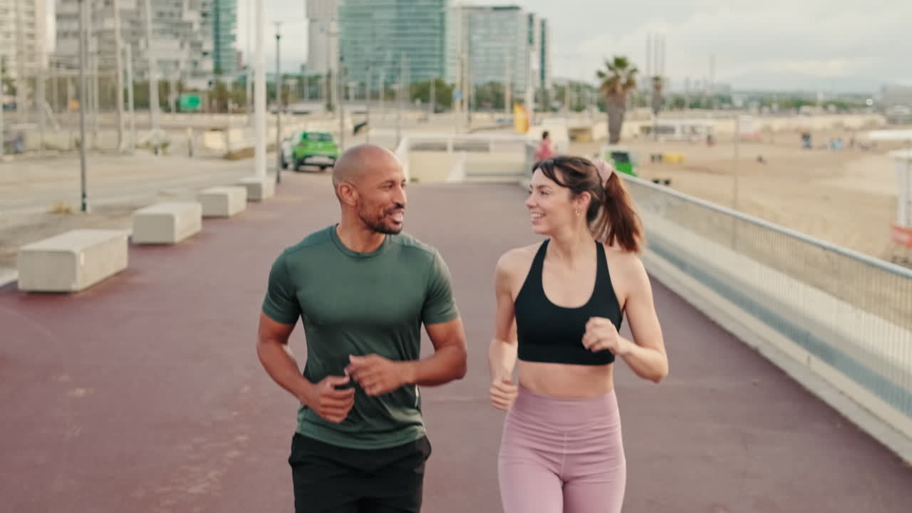 Cheerful Couple Running and Talking on Urban Waterfront