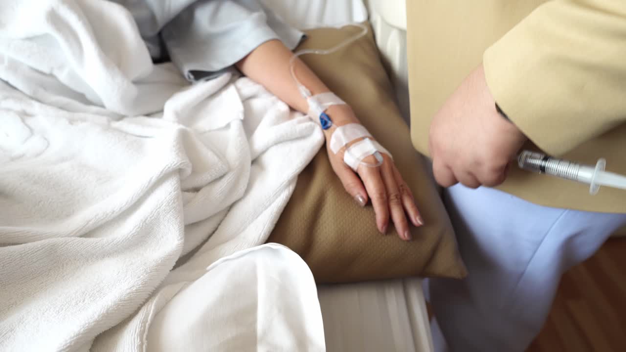 의사는 환자의 손에 테이프로 붙인 정맥 포트를 통해 진통제 또는 기타 약물을 주입합니다.