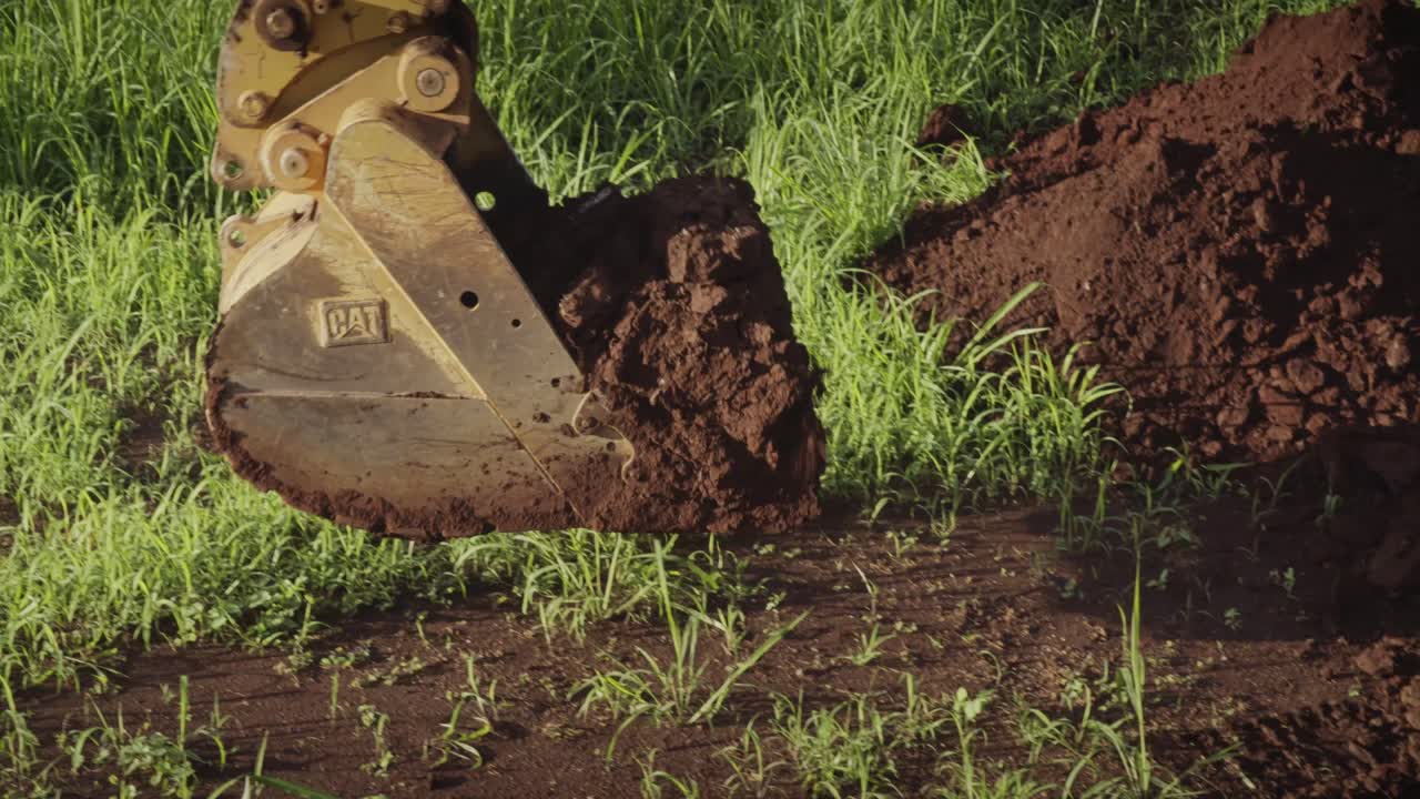la pala excavadora del tractor desentierra la suciedad