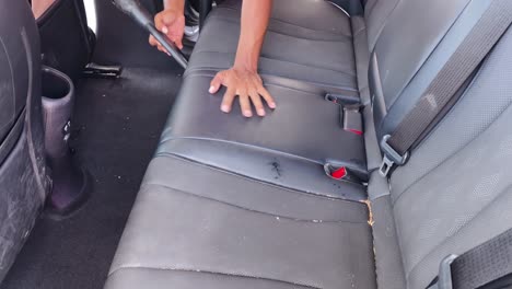 cleaning a car's interior seats with a vacuum