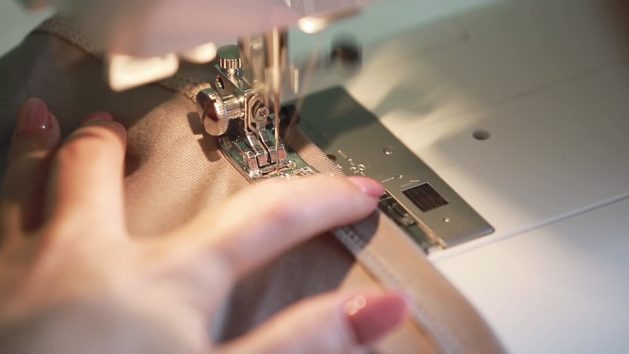 Dressmaker Woman Sews Clothes. Woman sewing at home on sewing machine