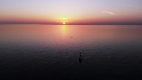 sun setting on the violet colored horizon on the endless peaceful ocean