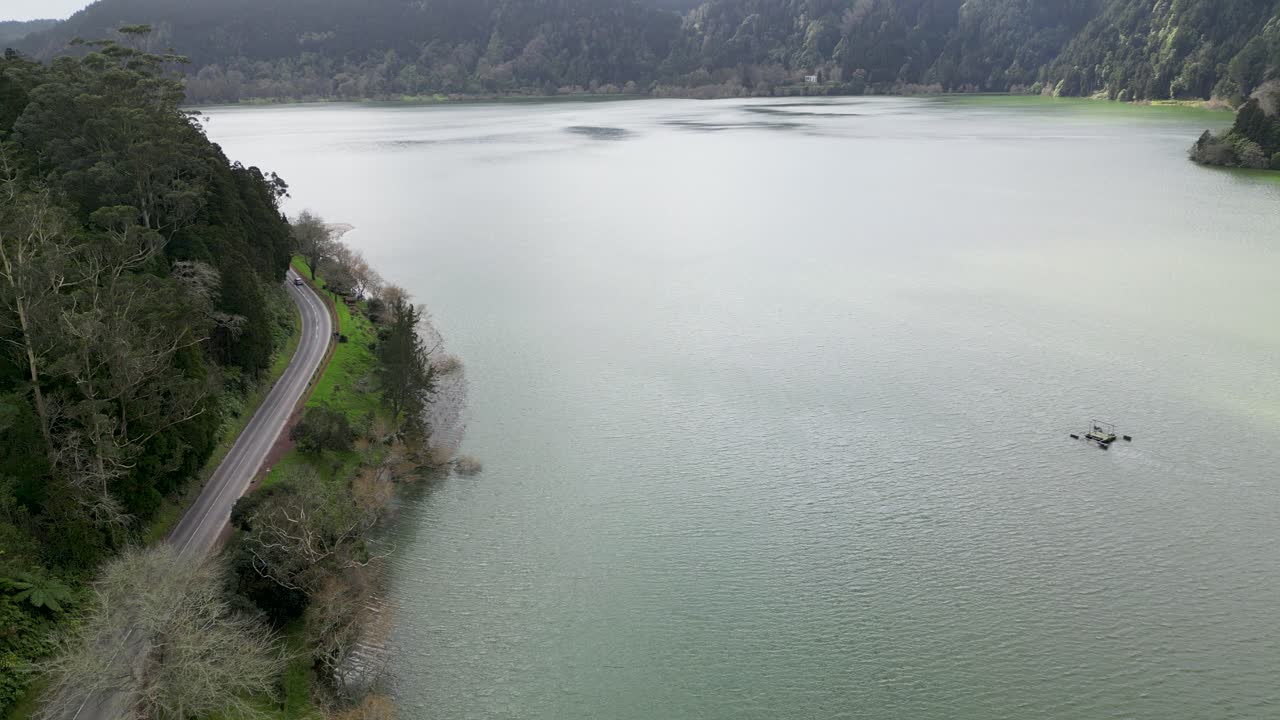 Aerial view of a mountain lake with a road running alongside it. Daylight