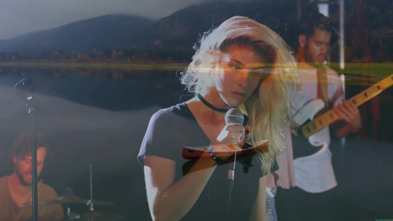 music industry female singer holding mic and singing on stage with canoe overlay and lake visual