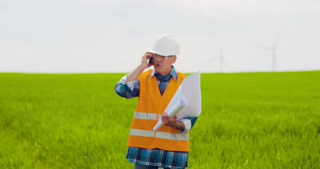 ingeniero enojado hablando por teléfono móvil en la granja