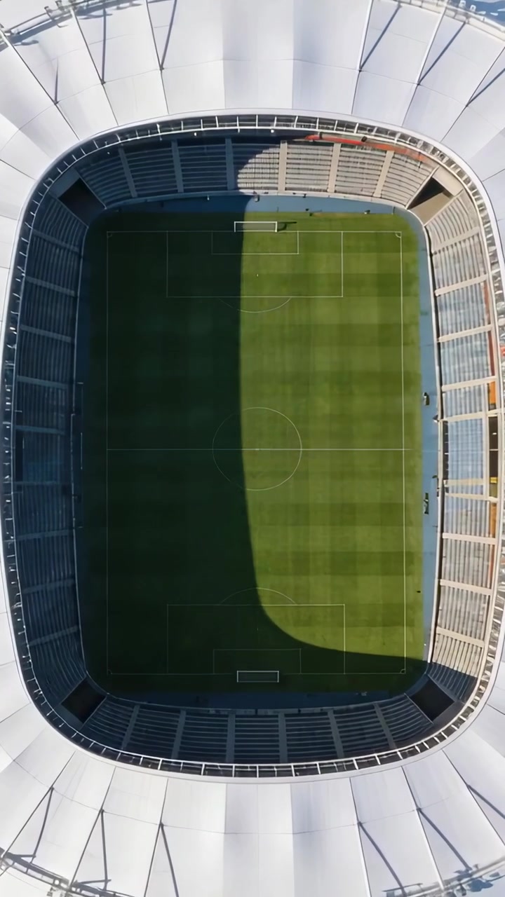 Video verticale: Pallone da calcio che entra dall'alto a destra, sfrecciando attraverso il campo dell'arena, con l'ombra che mostra l'erba