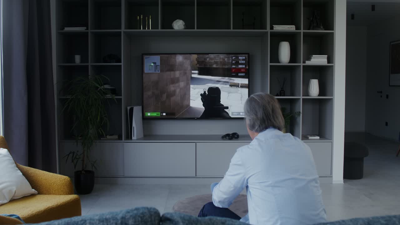 Man playing video game on console in living room