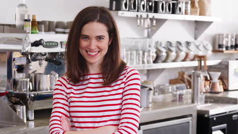 la dueña de la cafetería sonriendo detrás del mostrador, cerca