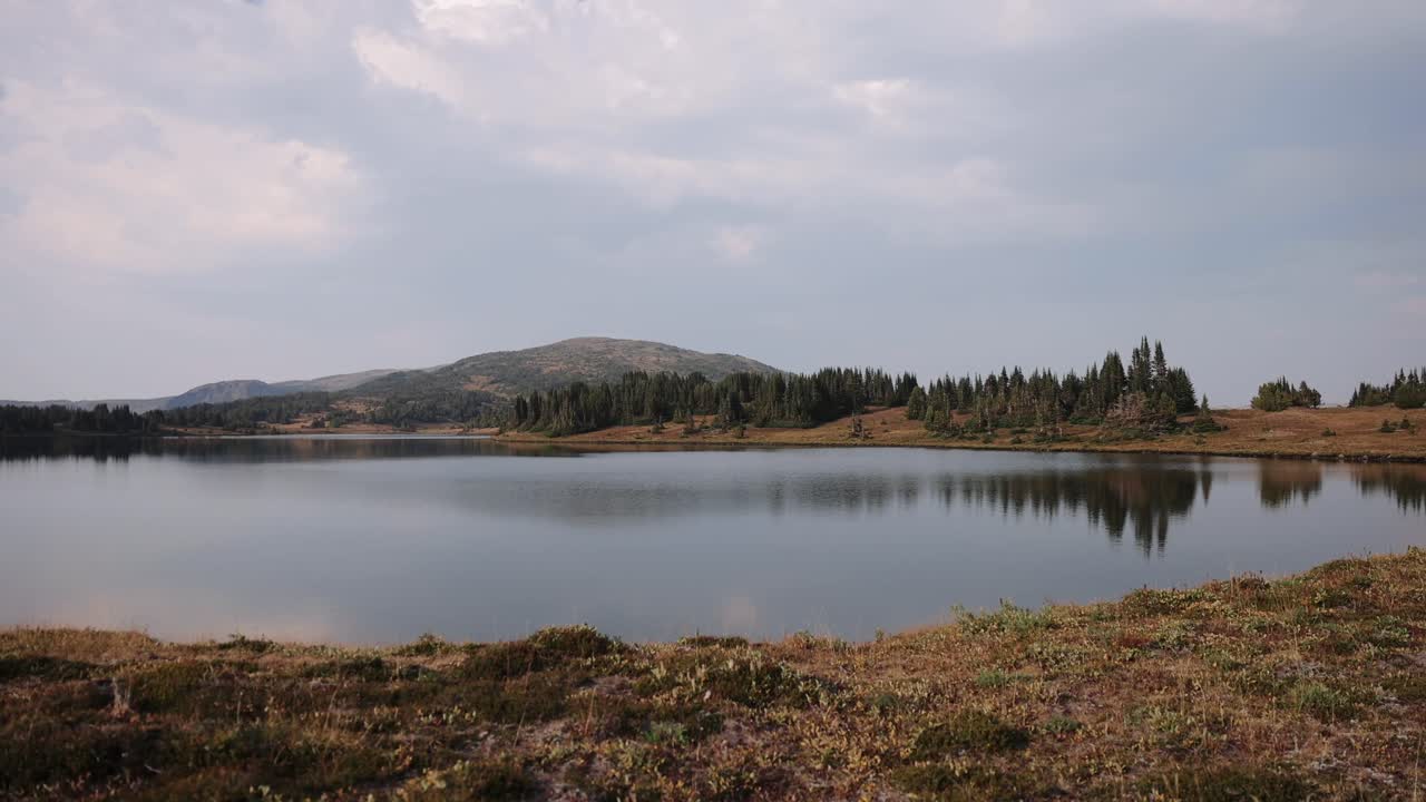 picos alpinos que se reflejan en un lago de montaña cristalino en primavera