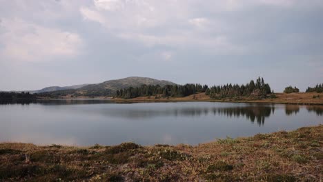 picos alpinos que se reflejan en un lago de montaña cristalino en primavera