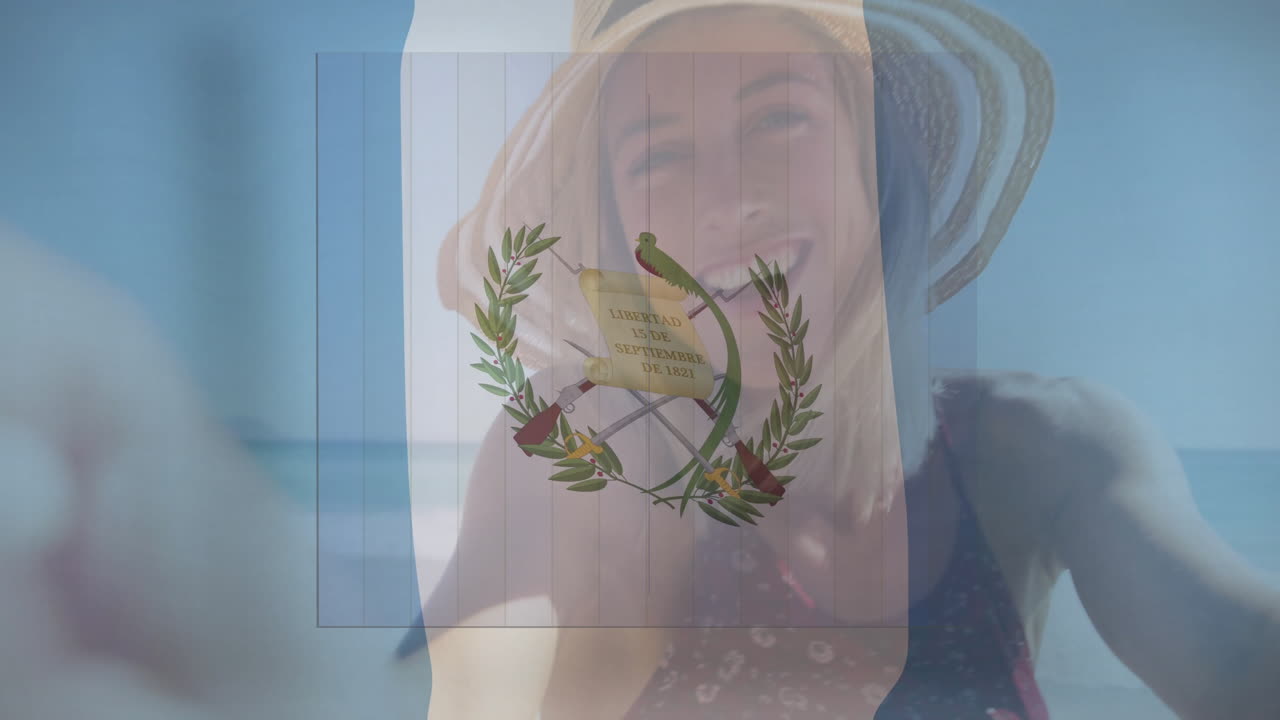Holding Guatemalan flag, person smiling with animation at beach scene