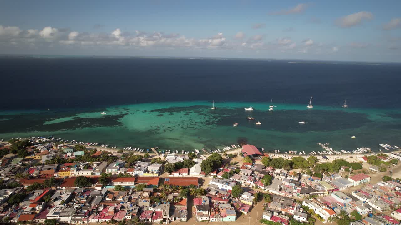 Gran roque island village with turquoise waters and boats in the distance, aerial view