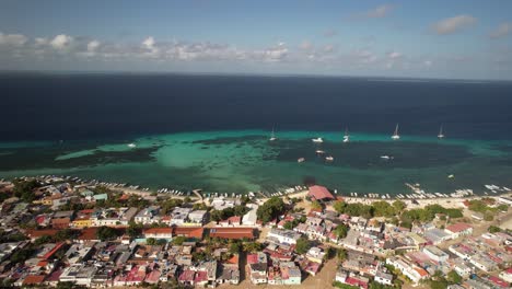 gran roque island village with turquoise waters and boats in the distance, aerial view