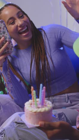 fotografía de estudio de video vertical de los amigos de la generación z celebrando el cumpleaños del hombre con pastel de fiesta y velas sentados en el sofá 1