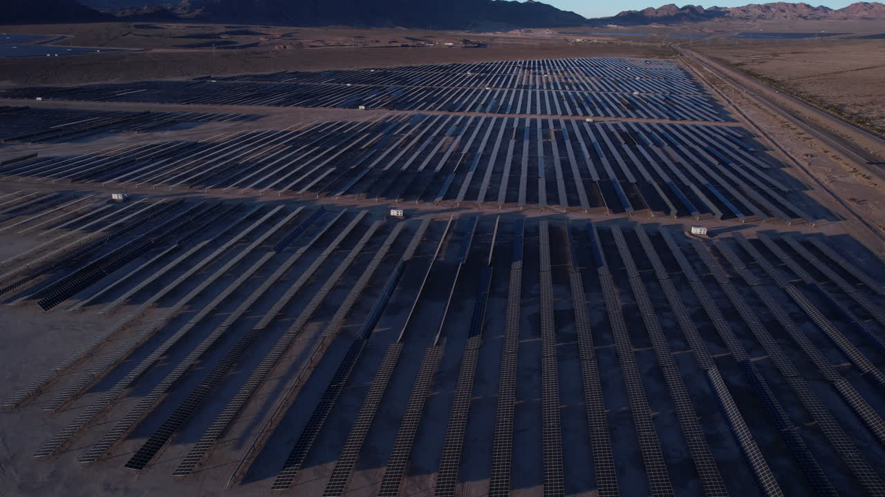 Luftfoto af solcellekraftværk, solcellepaneler i skumringen, droneoptagelse
