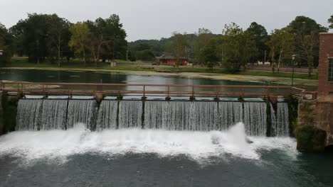 dam showing both the slow moving water side as well as the rushing water - drone angle straight on