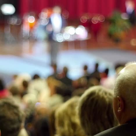 crowd of people to sitting and listening in a large hall