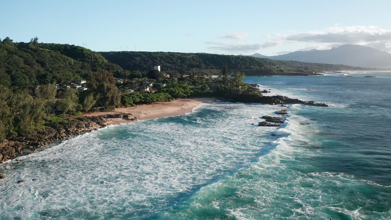 tiro aéreo bajo volando sobre los surfistas en una gran ola en la escarpada costa norte de hawaii