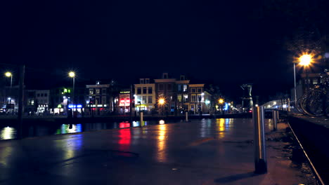 edificios iluminados y carretera concurrida en leiden, países bajos por la noche - panorámica lenta a la derecha, lapso de tiempo