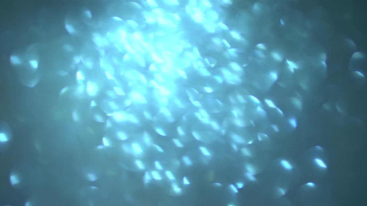 푸른 반이는 거품의 흐릿함, 수중의 추상적인 보케, 빛의 반사, 빛의 배경의 광선, 반이는 반이는 입자, 흐름, 흐름의 반이는 움직임, 움직임의 루프.