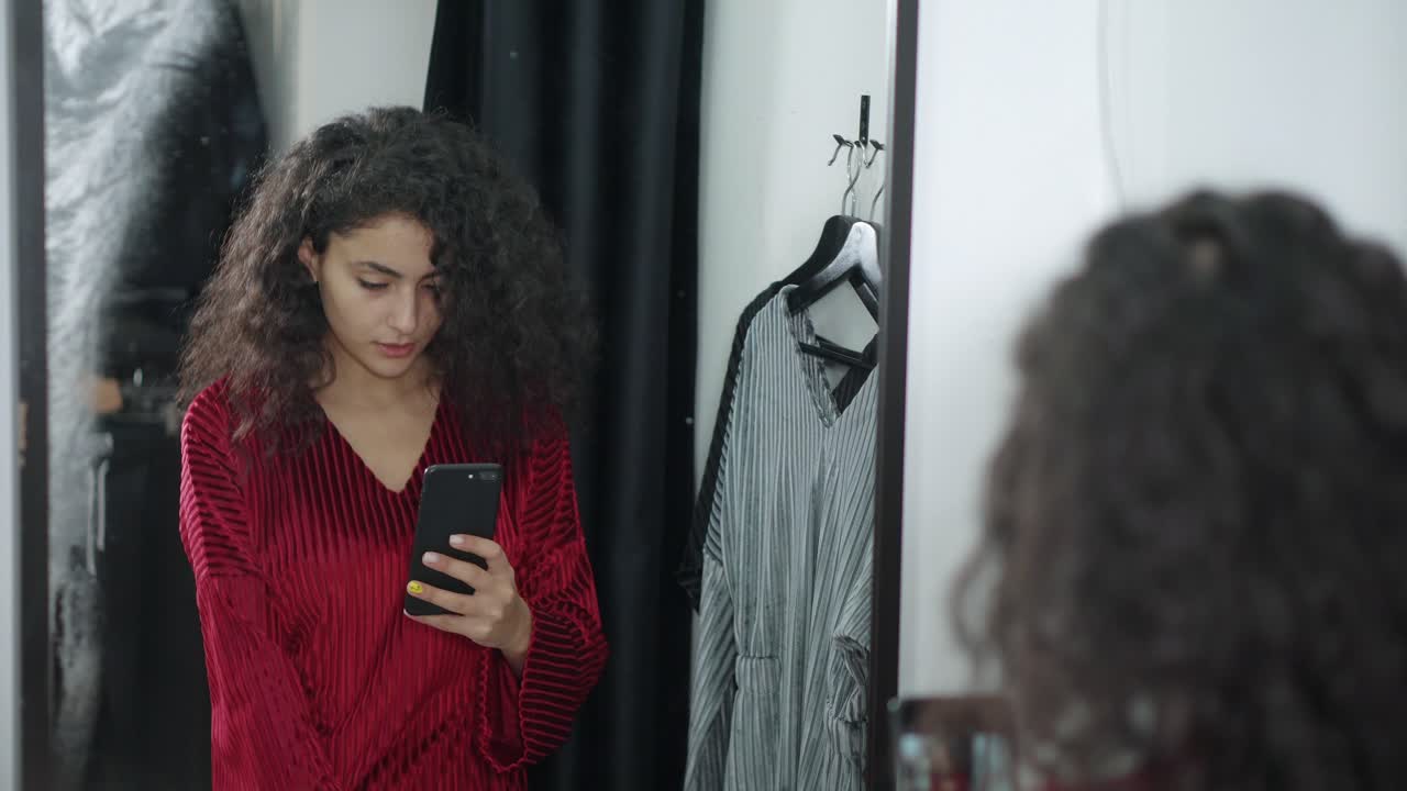 mujer probando ropa en un camerino