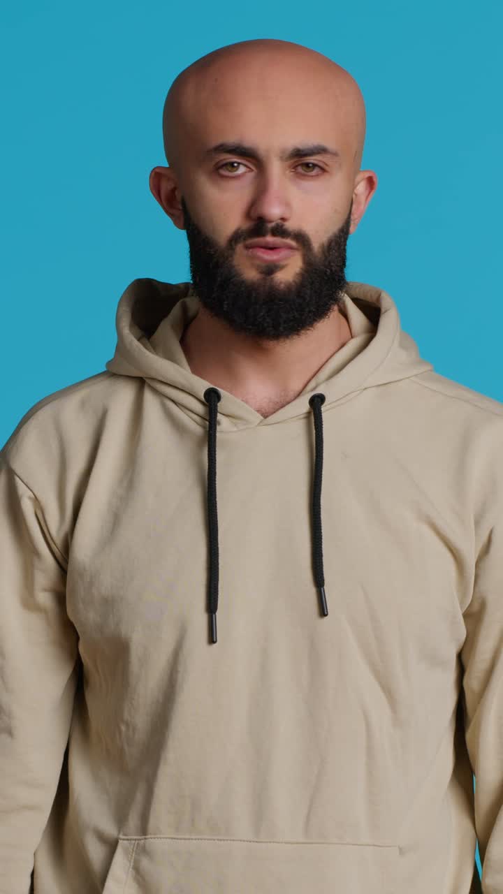 Vertical Video Young guy gesturing no sign over studio background