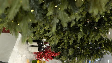 árbol de navidad y decoraciones de regalo en el centro comercial local, vista de movimiento vertical