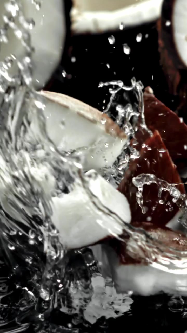 Pezzi di cocco fresco che schizzano nell'acqua al rallentatore