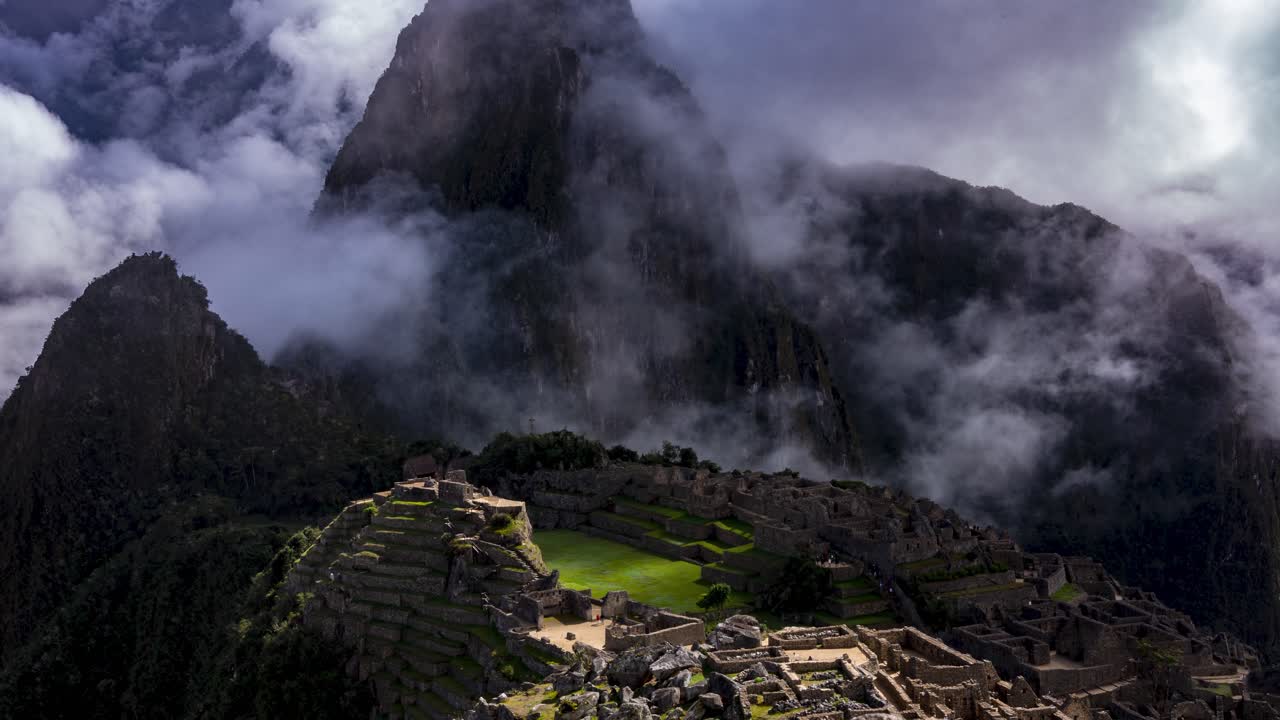 Time lapse view of the ancient Inca ruins of Machu Picchu covered in mist and clouds high in the Andes mountain range, Cusco Region, Peru.