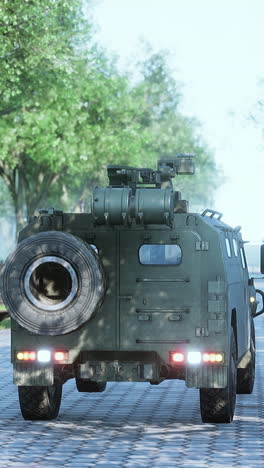 a green military armored vehicle driving down a paved road