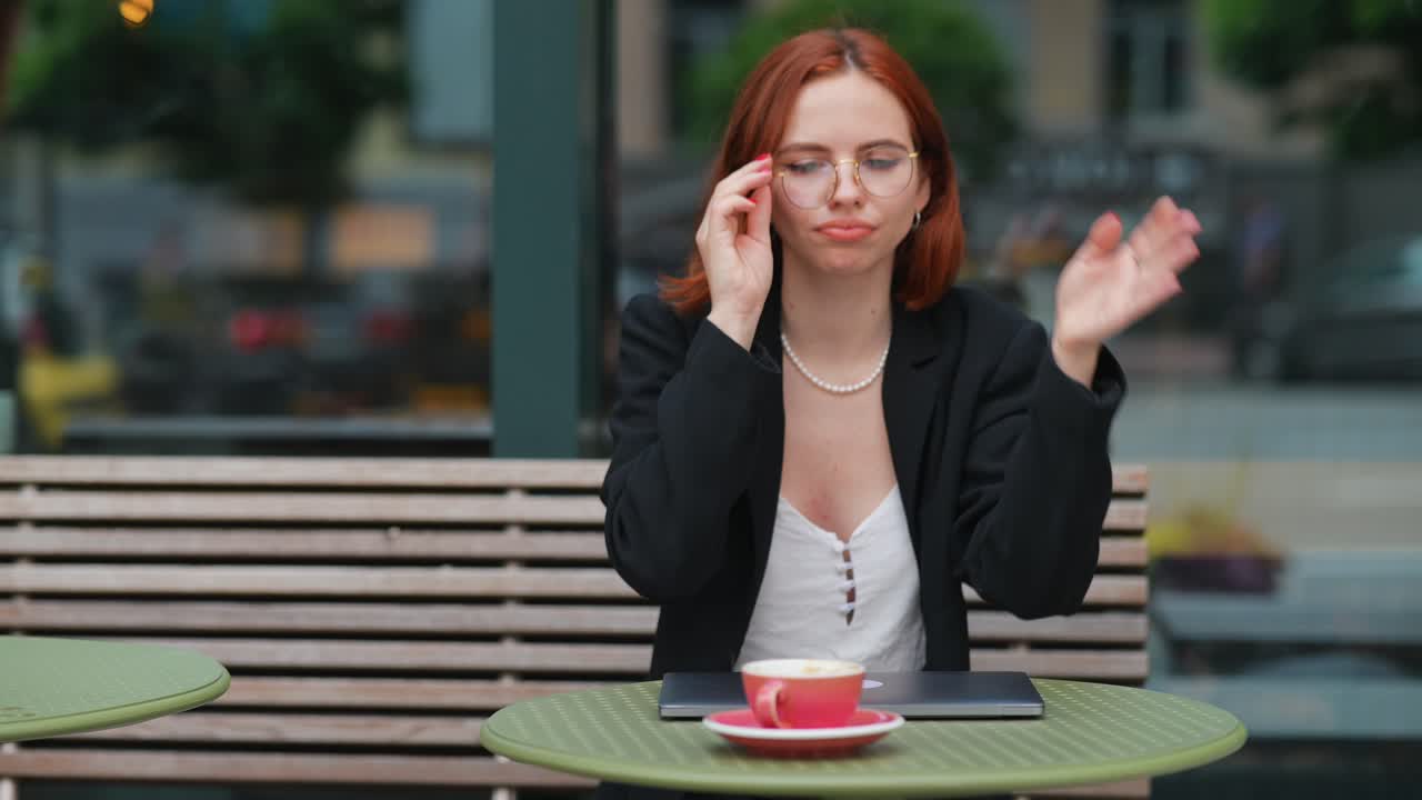 mujer trabajando en una computadora portátil en un café al aire libre