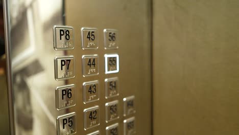 person pressing elevator buttons in dubai building