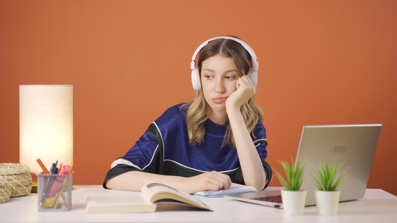 젊은 여성이 노트북을 보고 돈을 세고 있습니다.