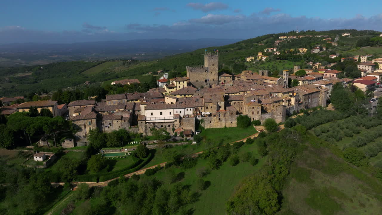 Antichi edifici in pietra sopra la città collinare di Castellina in Chianti, Toscana, Italia. Ripresa aerea con rotazione.