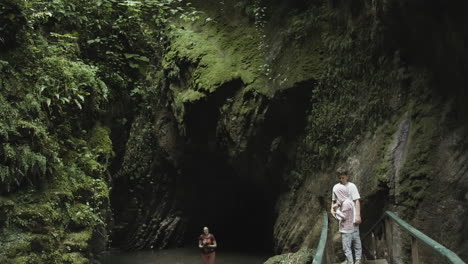 exploring a lush cave with waterfalls