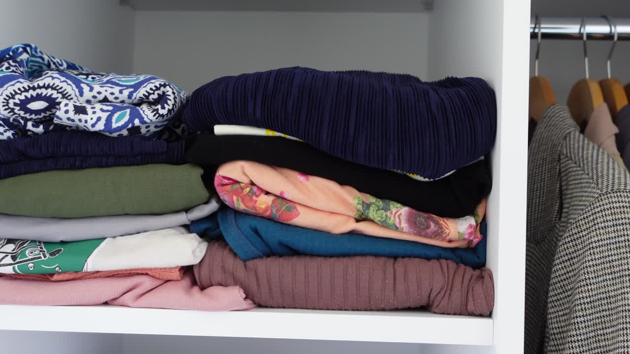 접힌 옷과 커가 있는 정리된 옷장