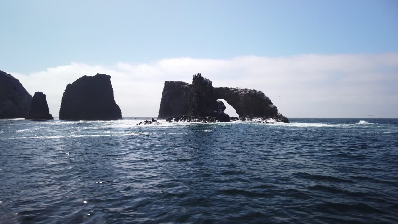 Gimbal close-up shot from a moving boat behind Arch Rock at East Anacapa Island, part of Channel Islands National Park, California