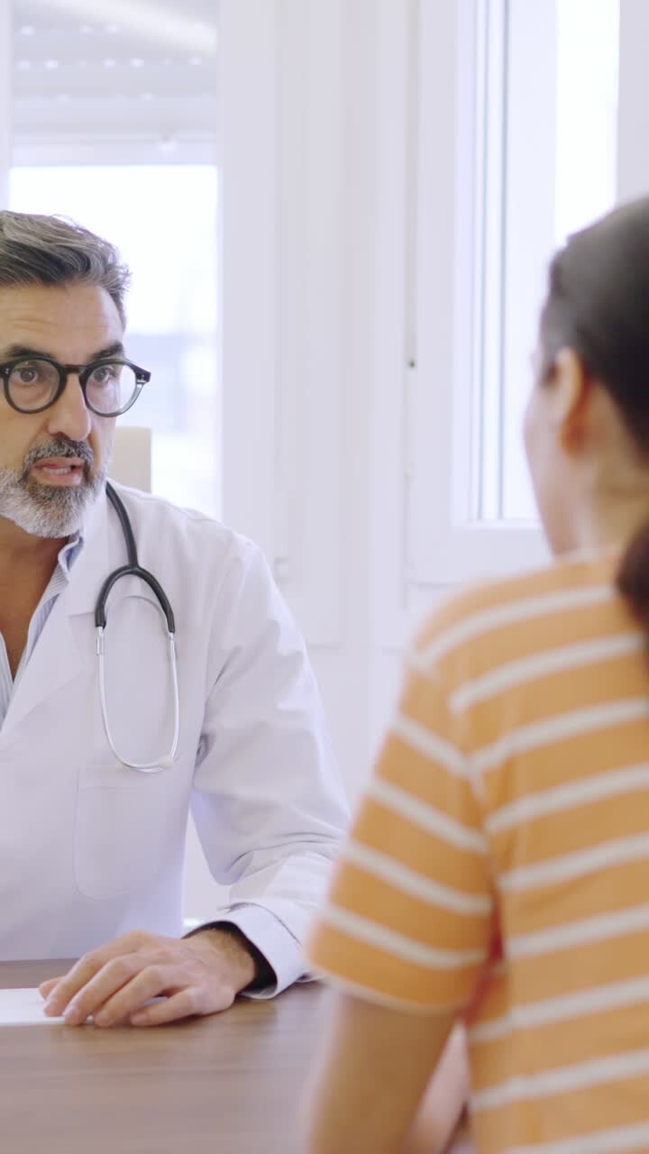 Doctor talking with a woman while writing down notes