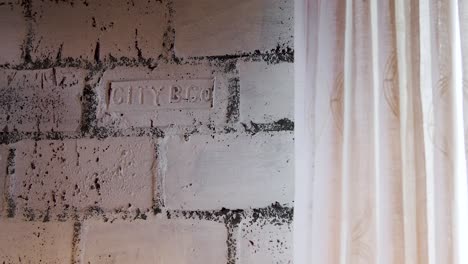 white brick wall with sheer curtain