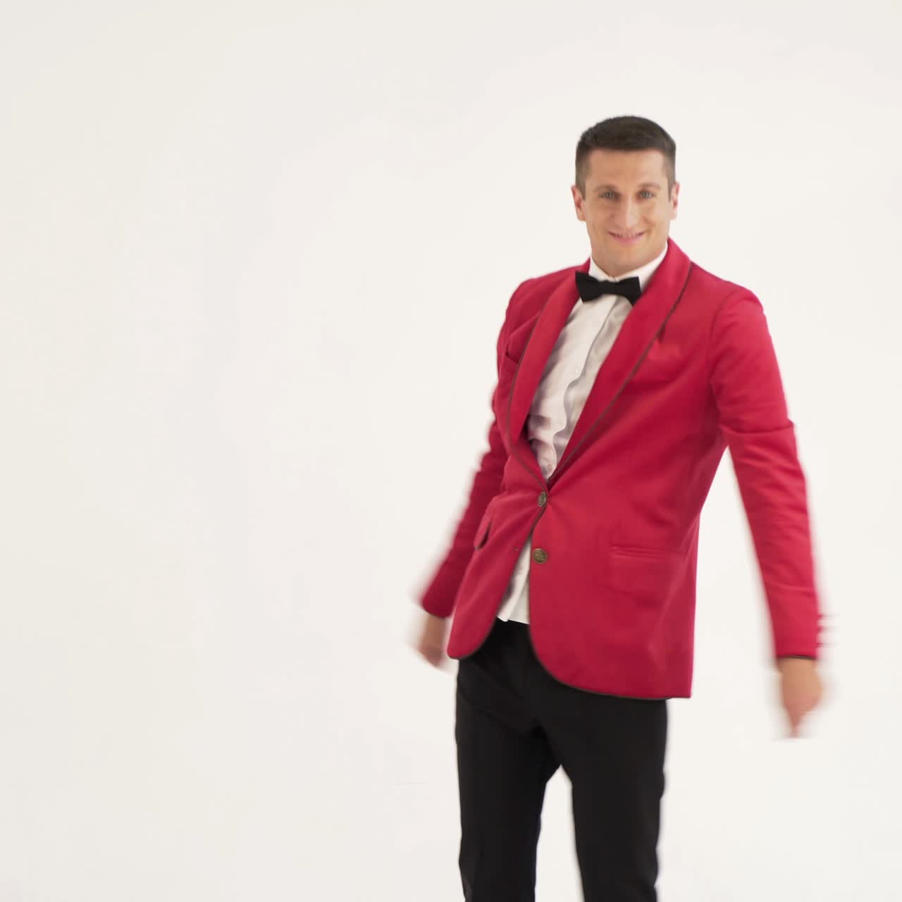 funny man in red suit is making funny movement with his hands and body on a white background in the studio. Fool around