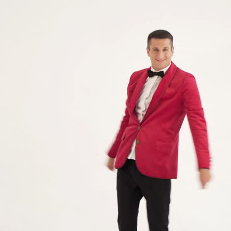 funny man in red suit is making funny movement with his hands and body on a white background in the studio. fool around