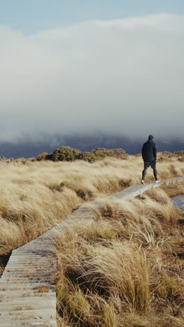 hiking on a wooden boardwalk through a misty mountain landscape