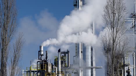 Chimeneas-Humeantes-De-Las-Grandes-Instalaciones-Químicas-En-Una-Refinería-De-Petróleo