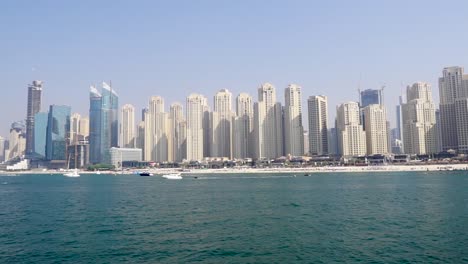 boats on the beach in dubai with skyscrapers in the background